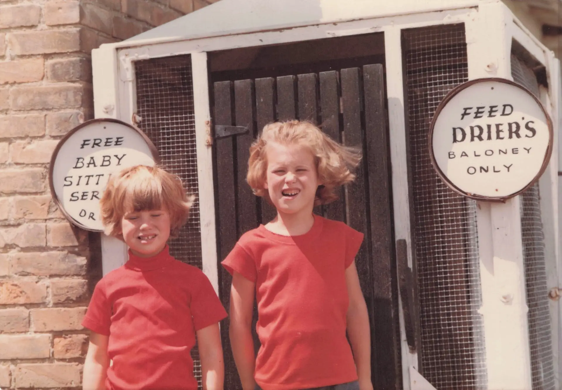 Vintage color photograph of two young girls in matching red outfits, part of the Drier family history at Drier's Meat Market